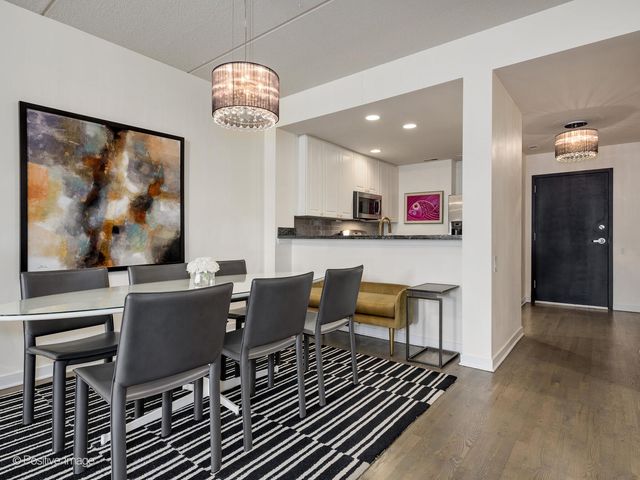 a dining room with furniture a chandelier and wooden floor