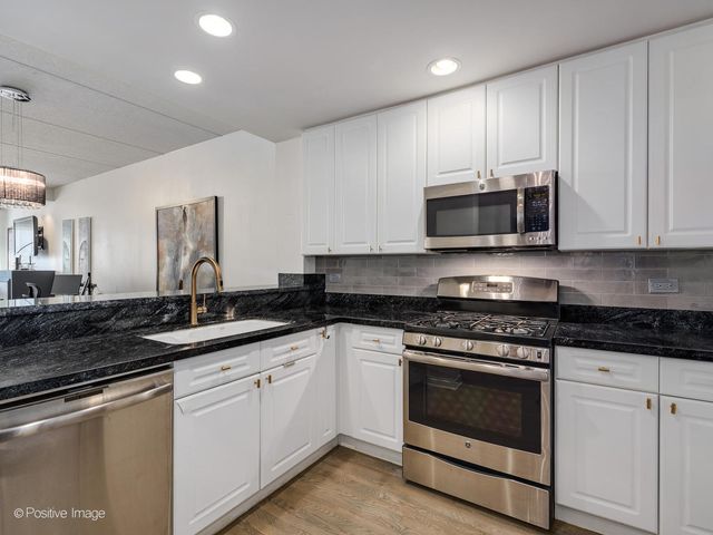 a kitchen with stainless steel appliances granite countertop a sink and a stove