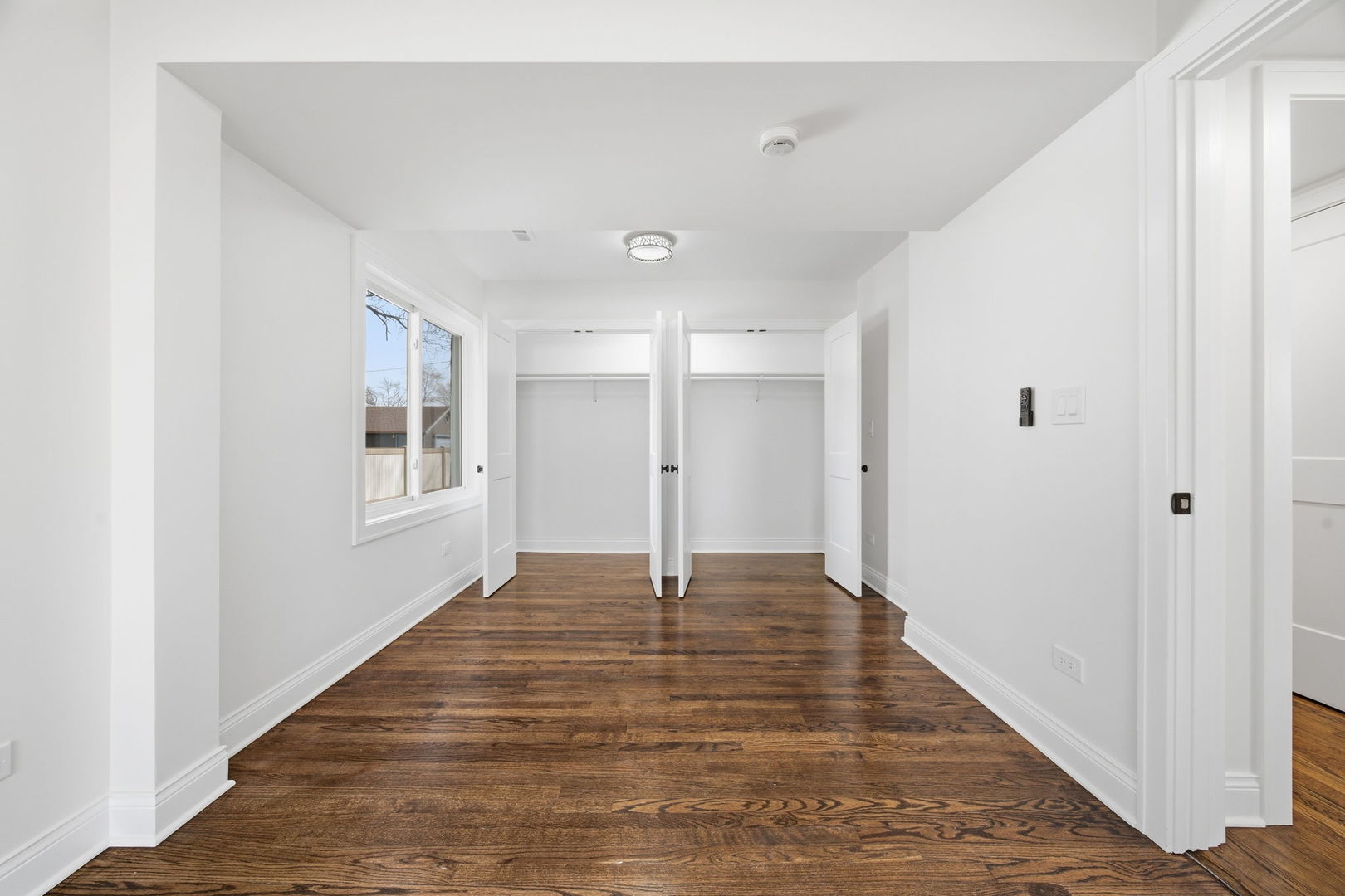 7851 Suburban Lane Bridgeview, IL 60455 - Photo 20 of 50 a view of an empty room with wooden floor and a window