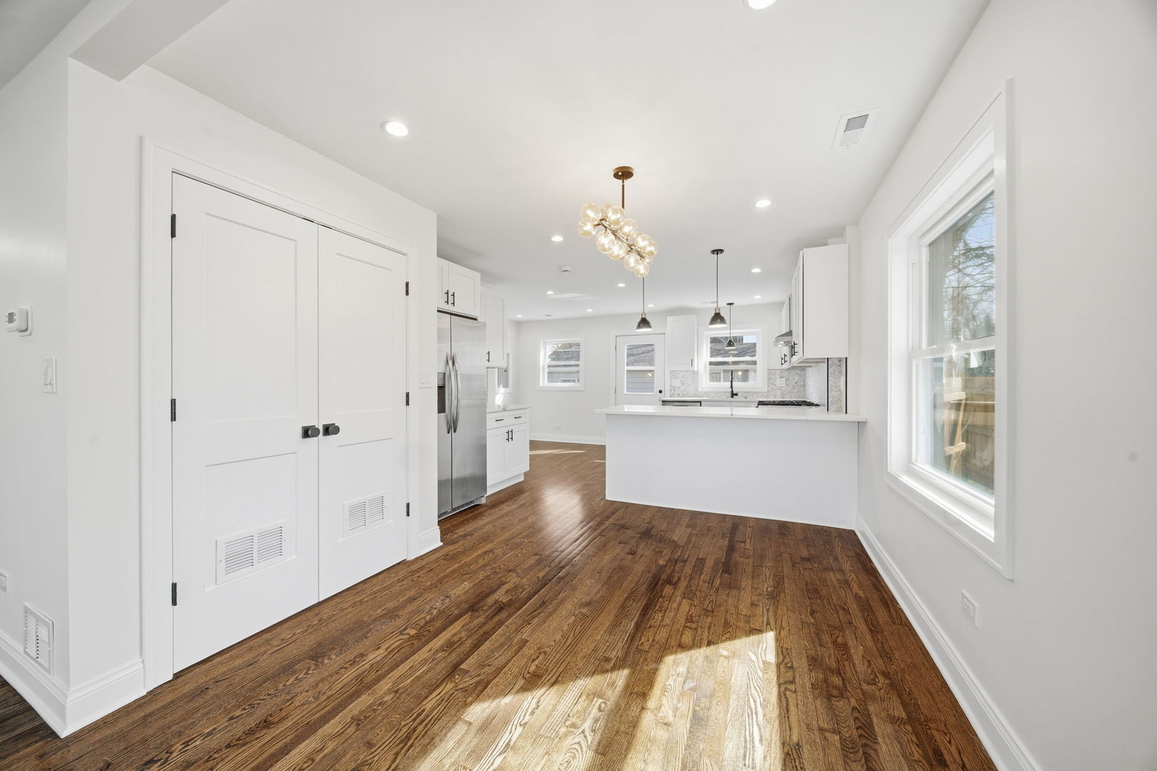 7851 Suburban Lane Bridgeview, IL 60455 - Photo 8 of 50 a open kitchen with white cabinets and wooden floor