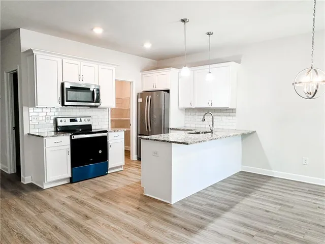 a kitchen with kitchen island granite countertop stainless steel appliances cabinets a sink and a center island