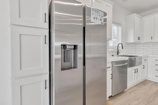 a kitchen with white cabinets and white appliances