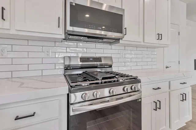 a stove top oven sitting inside of a kitchen