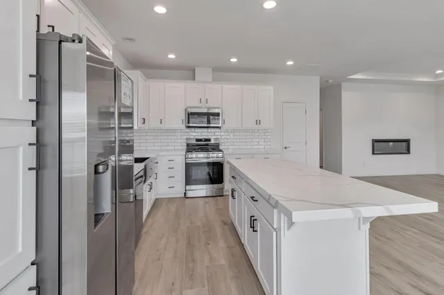 a kitchen with stainless steel appliances a refrigerator sink and cabinets