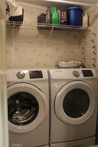 a kitchen with stainless steel appliances a sink a stove a refrigerator cabinets and a window