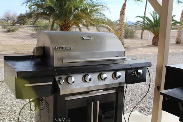 a view of a fireplace with a table and chairs under an umbrella