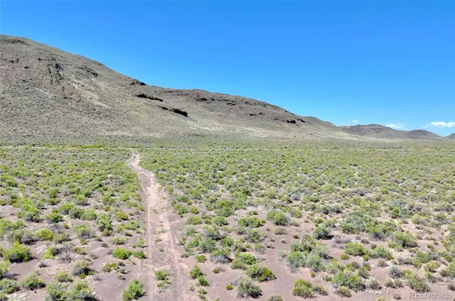 a view of a mountain range with lush green forest