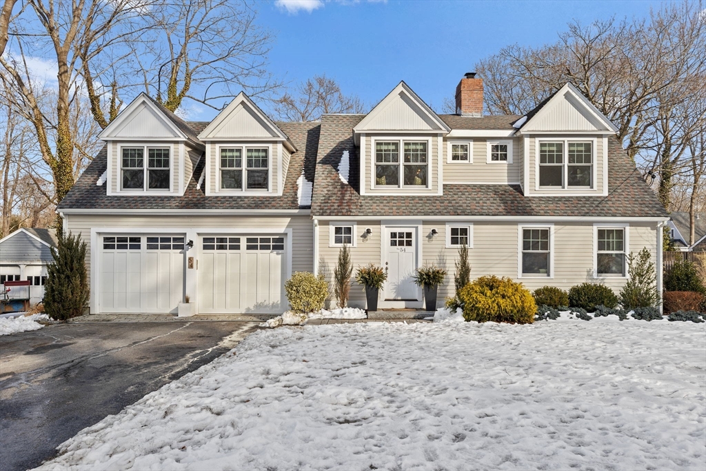 a view of a white house with a yard and large windows