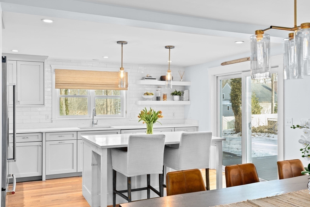 54 Dreamwold Road Scituate, MA 02066 - Photo 6 of 41 a kitchen with a dining table chairs stainless steel appliances and windows