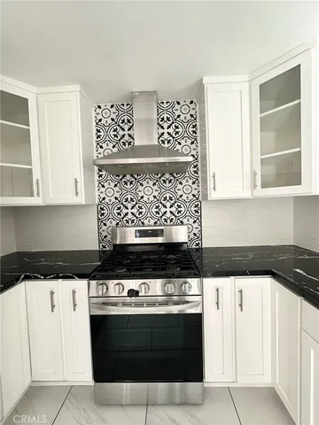 a kitchen with granite countertop white cabinets and a sink