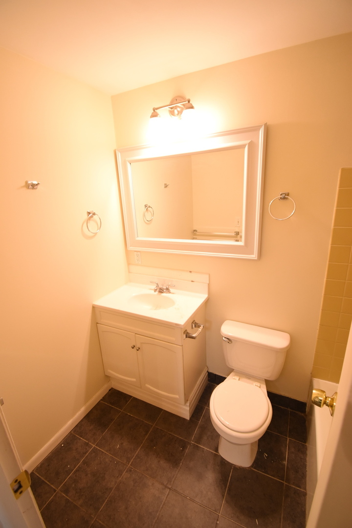 4618 Northfox Lane, Unit 6 McHenry, IL 60050 - Photo 10 of 15 a bathroom with a toilet a sink and mirror