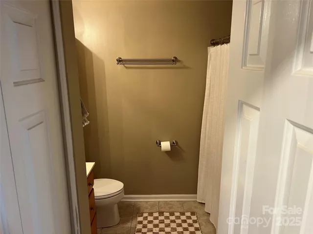 a bathroom with a granite countertop toilet and a shower