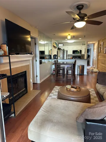 a living room with furniture a flat screen tv and kitchen view