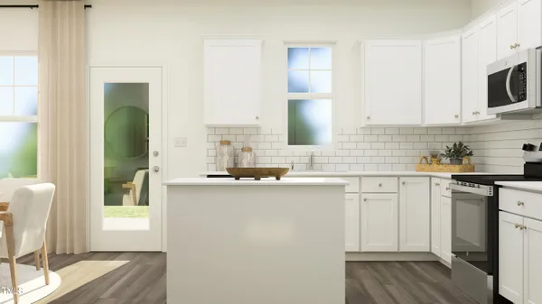 a kitchen with stainless steel appliances a white cabinets and a wooden floor