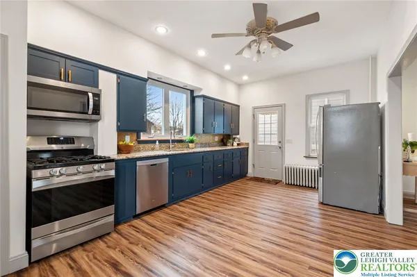 a kitchen with stainless steel appliances granite countertop a refrigerator stove and sink