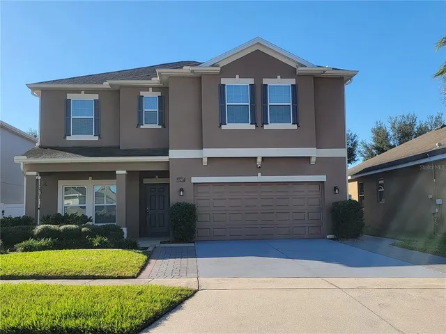a front view of a house with a yard and garage