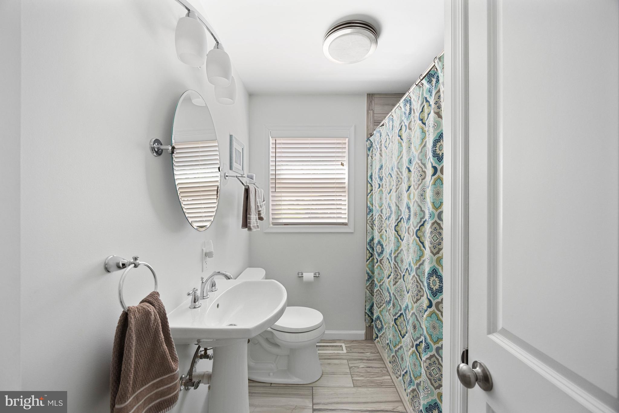 511 Greenwood Road Linthicum Heights, MD 21090 - Photo 13 of 26 a bathroom with a toilet a sink and a mirror