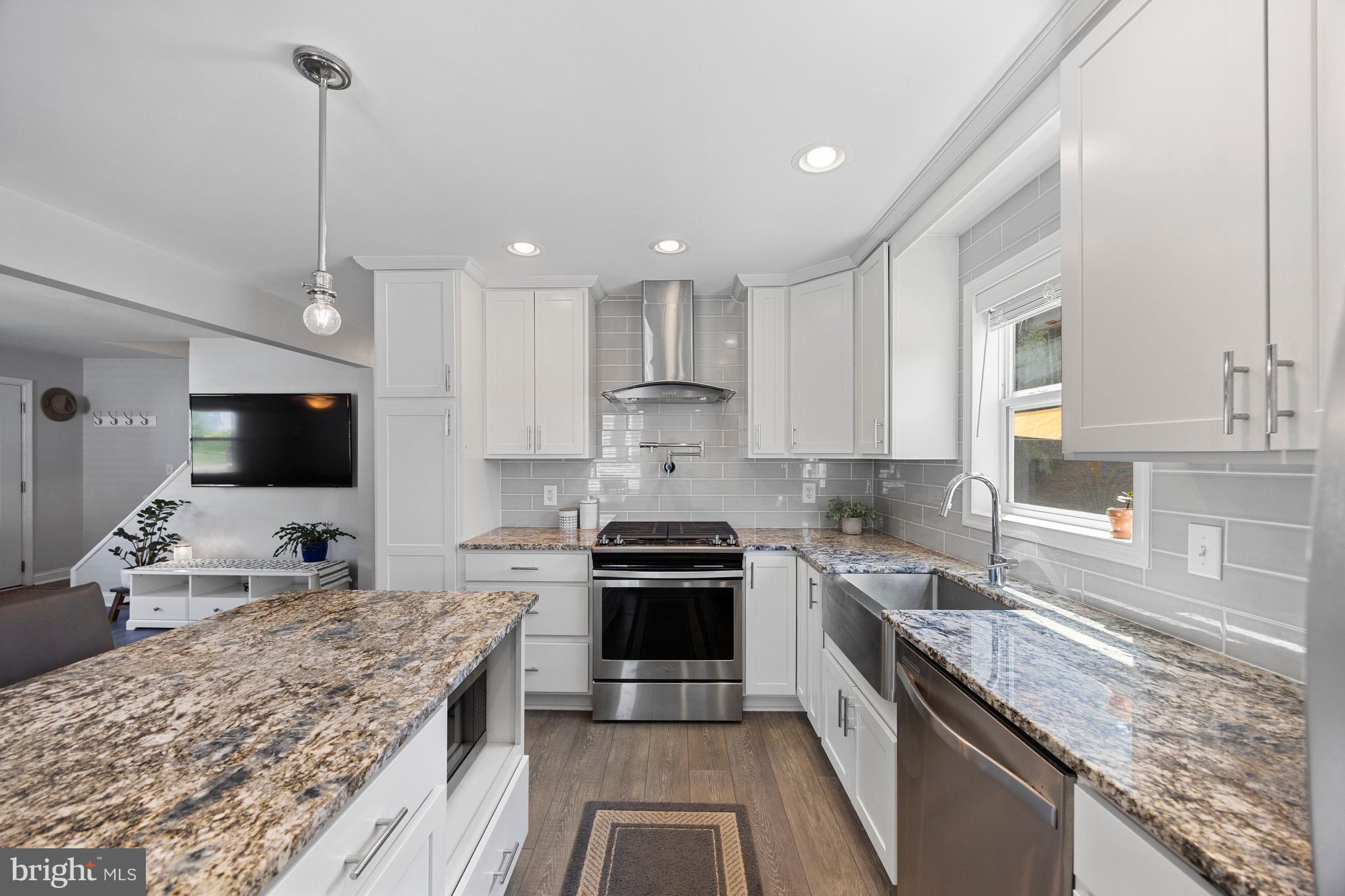 511 Greenwood Road Linthicum Heights, MD 21090 - Photo 5 of 26 a kitchen with kitchen island granite countertop stainless steel appliances a stove sink microwave and cabinets