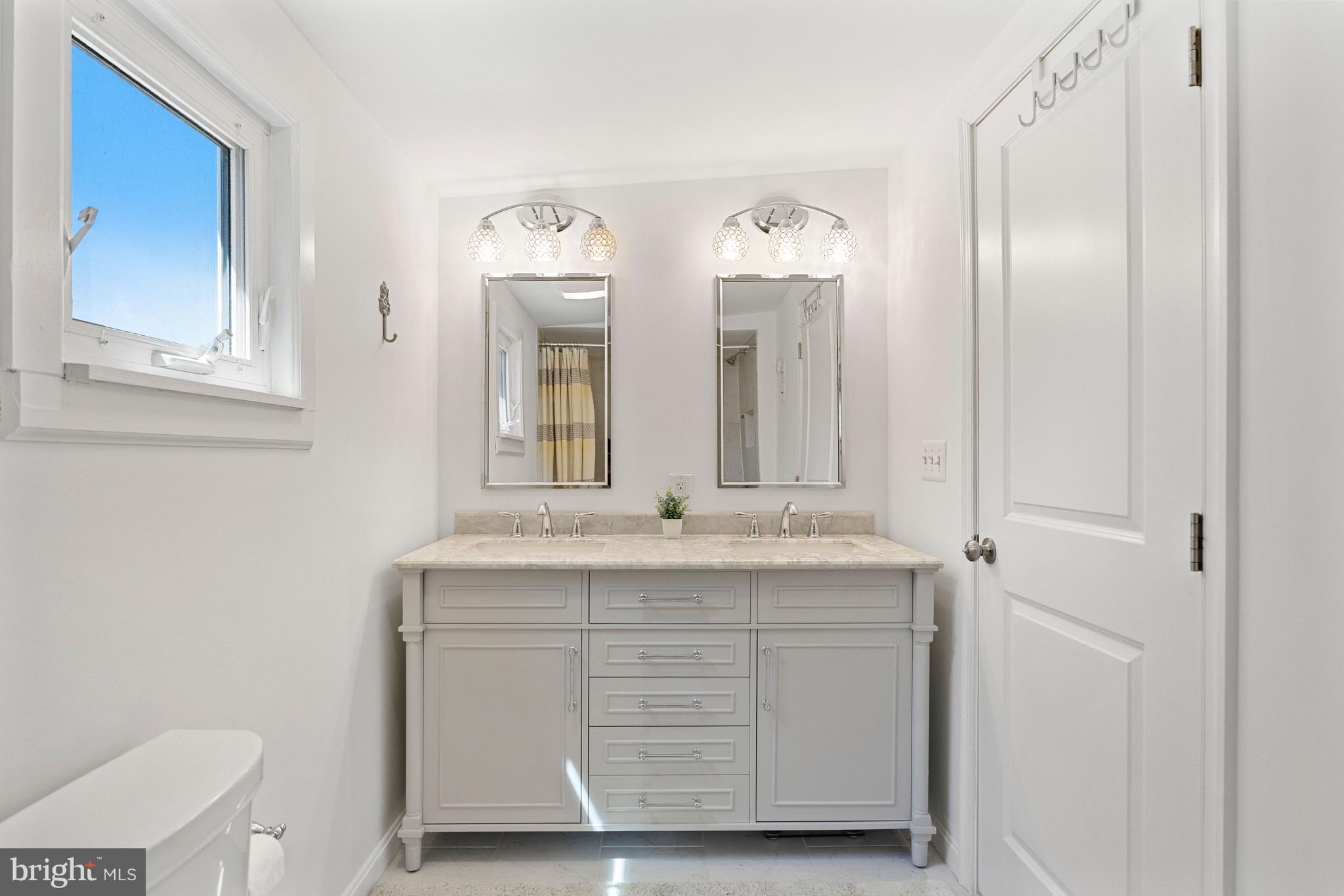 511 Greenwood Road Linthicum Heights, MD 21090 - Photo 9 of 26 a bathroom with a double vanity sink and a mirror