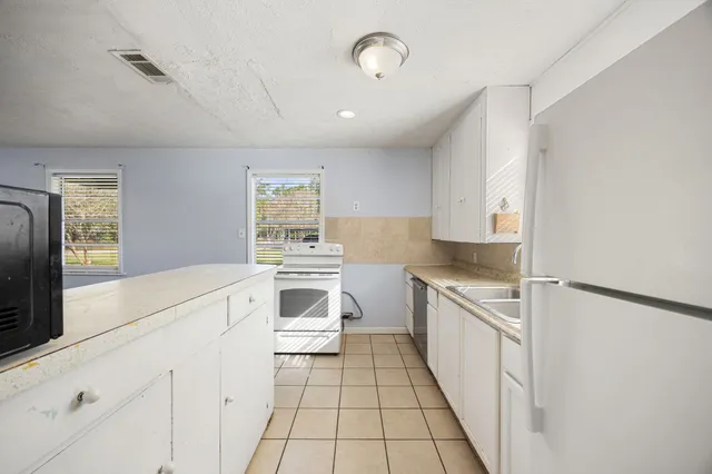 a kitchen with white cabinets and white appliances