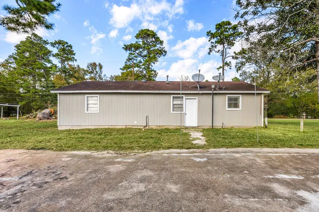 a view of a house with yard and a large tree