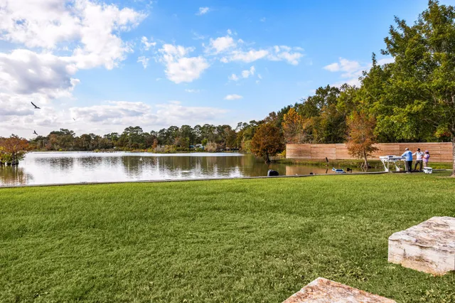 a front view of a house with a garden and lake view