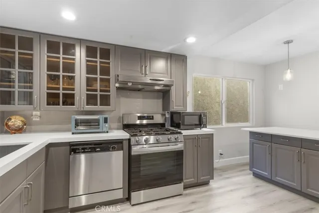 a kitchen with granite countertop a stove sink and cabinets