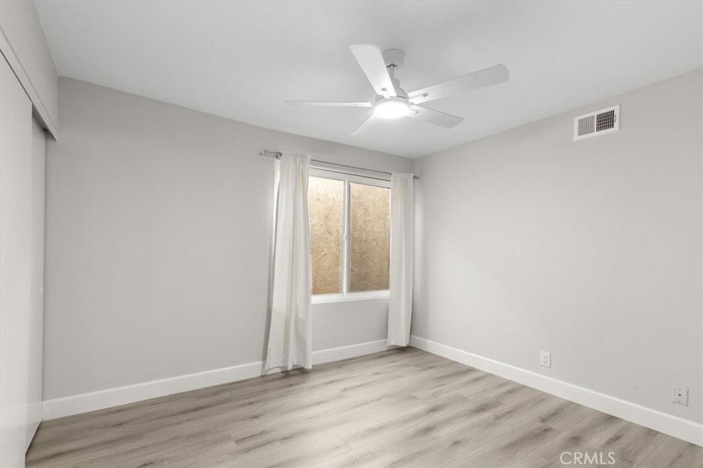 1353 Termino Avenue Long Beach, CA 90804 - Photo 15 of 33 an empty room with wooden floor fan and windows