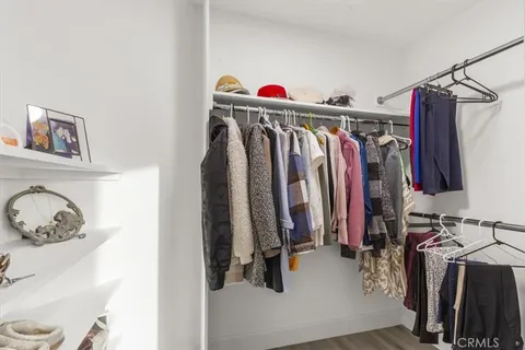 a view of walk in closet with clothes and shoes