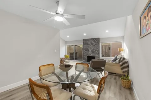 a dining room with furniture and a chandelier fan