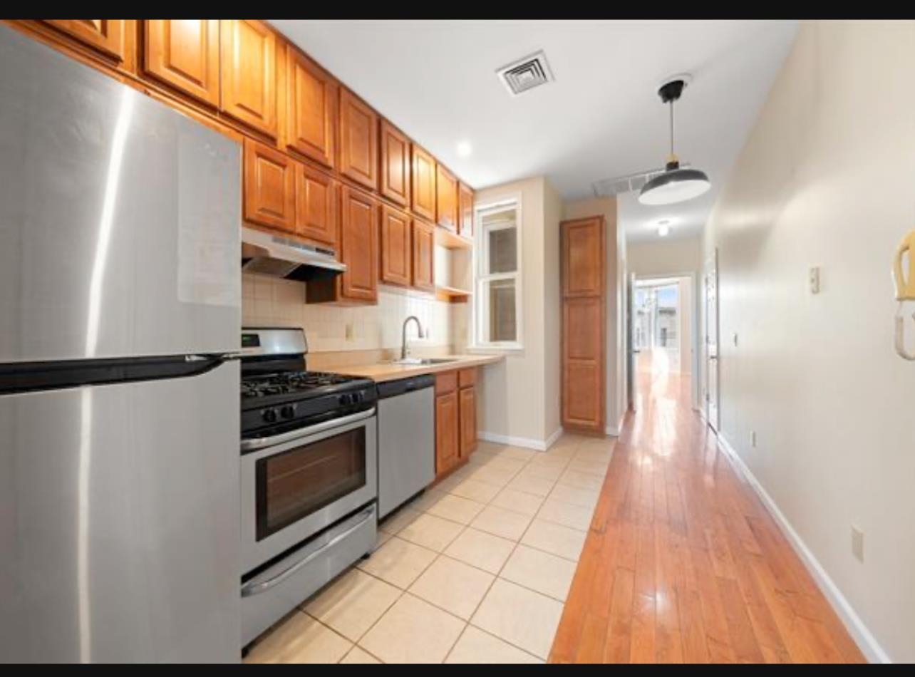 54 Monitor Street, Unit 4A Jersey City, NJ 07304 - Photo 2 of 10 a kitchen with stainless steel appliances granite countertop a stove a refrigerator and a microwave