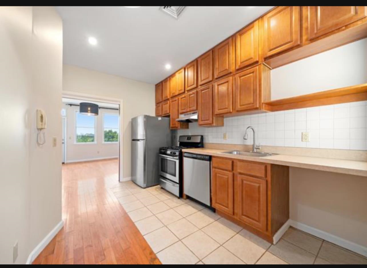 54 Monitor Street, Unit 4A Jersey City, NJ 07304 - Photo 5 of 10 a kitchen with refrigerator and window