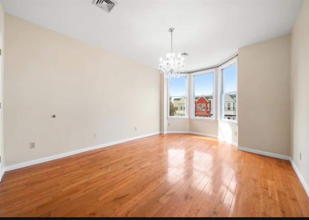 54 Monitor Street, Unit 4A Jersey City, NJ 07304 - Photo 6 of 10 a view of an empty room with kitchen and a window