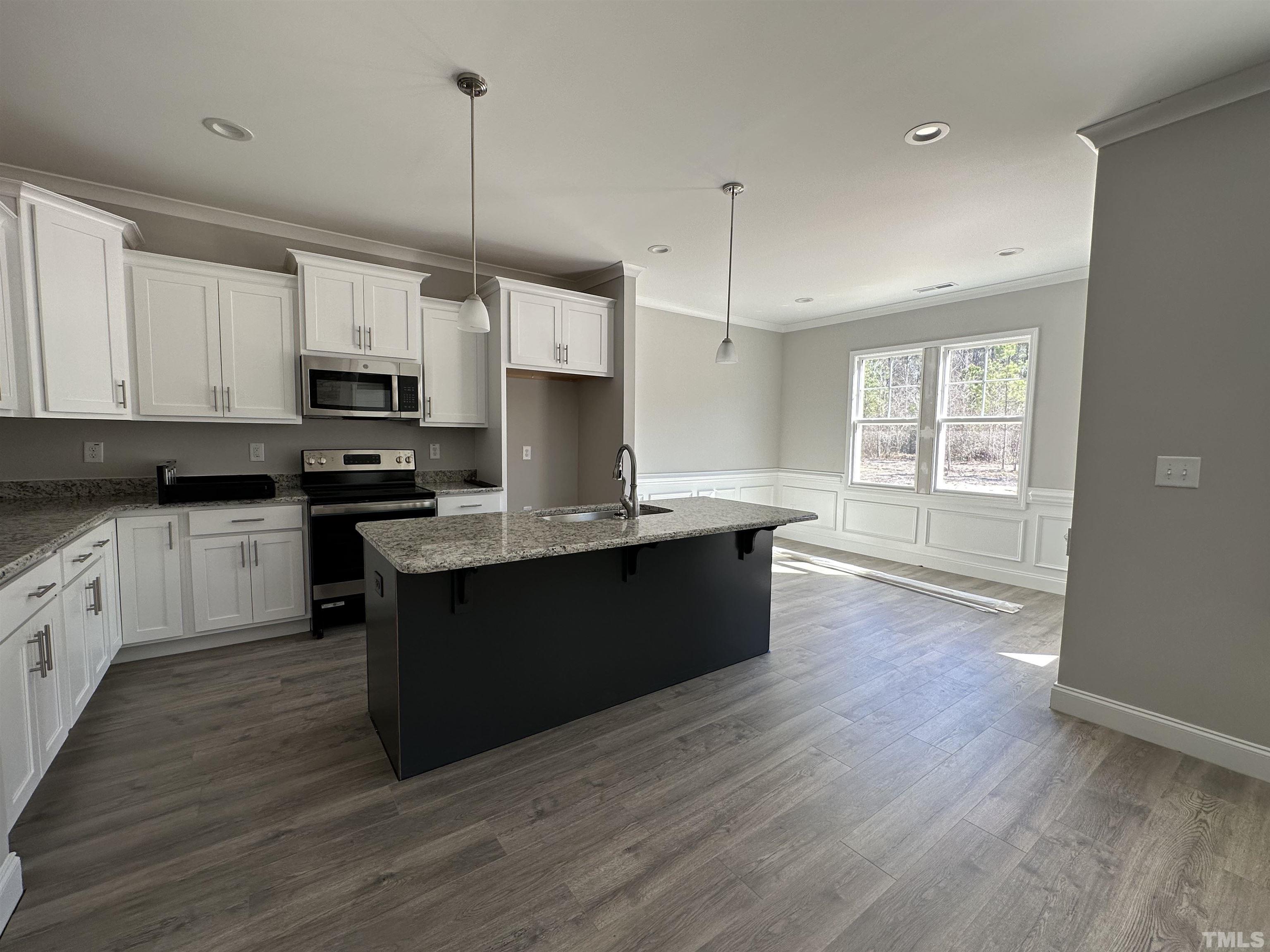 448 Jackson Pond Drive Smithfield, NC 27577 - Photo 14 of 25 a kitchen with kitchen island granite countertop a sink dishwasher a refrigerator a stove top oven a kitchen island with wooden floor and cabinets