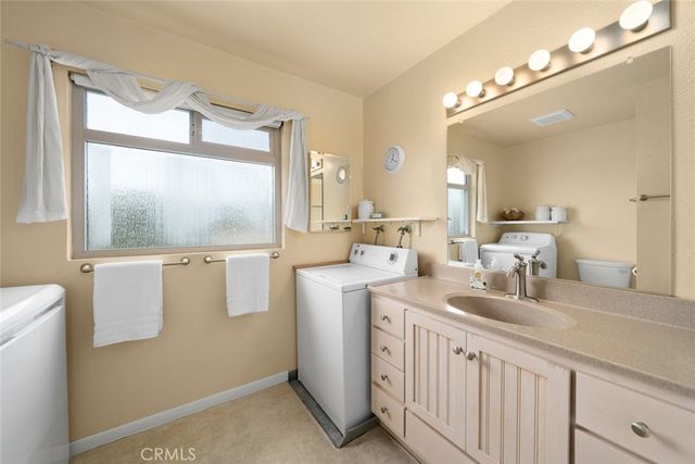 a bathroom with a double vanity sink mirror and a toilet
