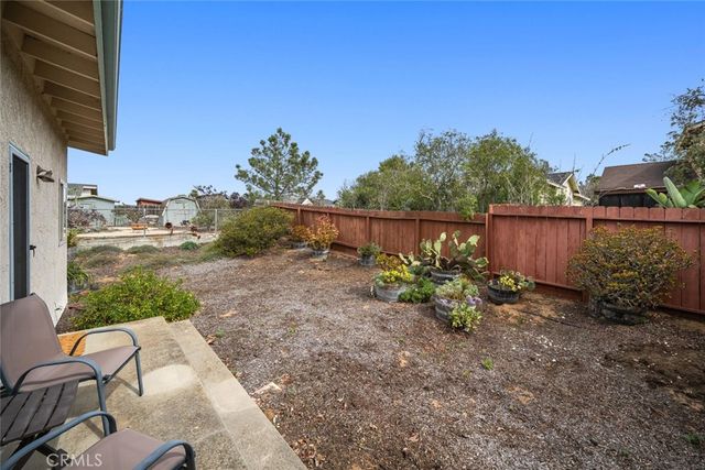 a backyard of a house with table and chairs