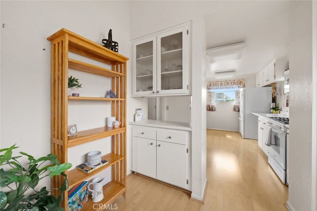 a hallway with white cabinets and wooden floor