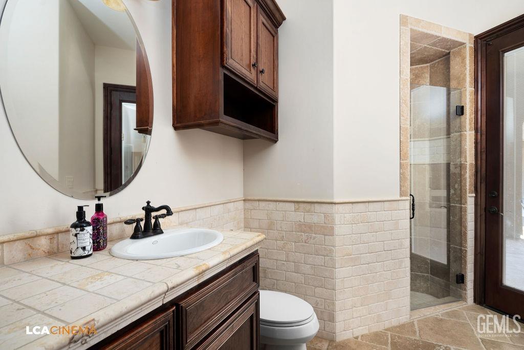 Undisclosed Address Keene, CA 93531 - Photo 19 of 46 a bathroom with a granite countertop sink a toilet a mirror and shower