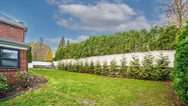 a view of a house with a big yard plants and large trees
