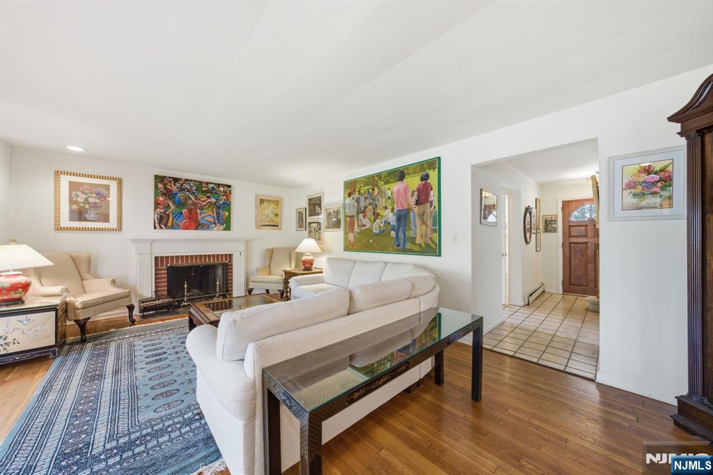 168 Engle Street Tenafly, NJ 07670 - Photo 20 of 50 a living room with furniture a fireplace and paintings on the wall