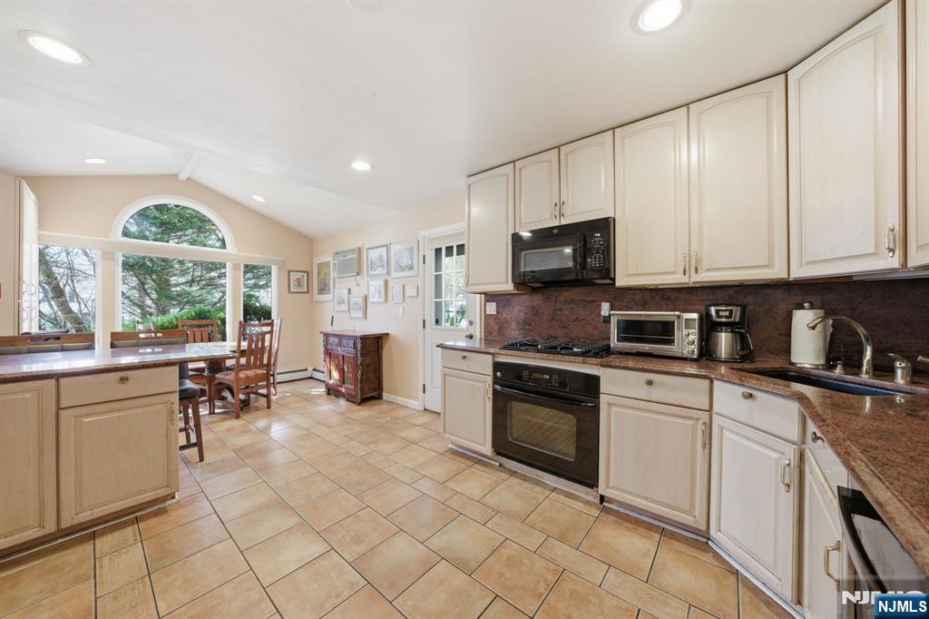 168 Engle Street Tenafly, NJ 07670 - Photo 9 of 50 a kitchen with stainless steel appliances granite countertop a stove top oven a sink dishwasher a dining table and chairs with wooden floor