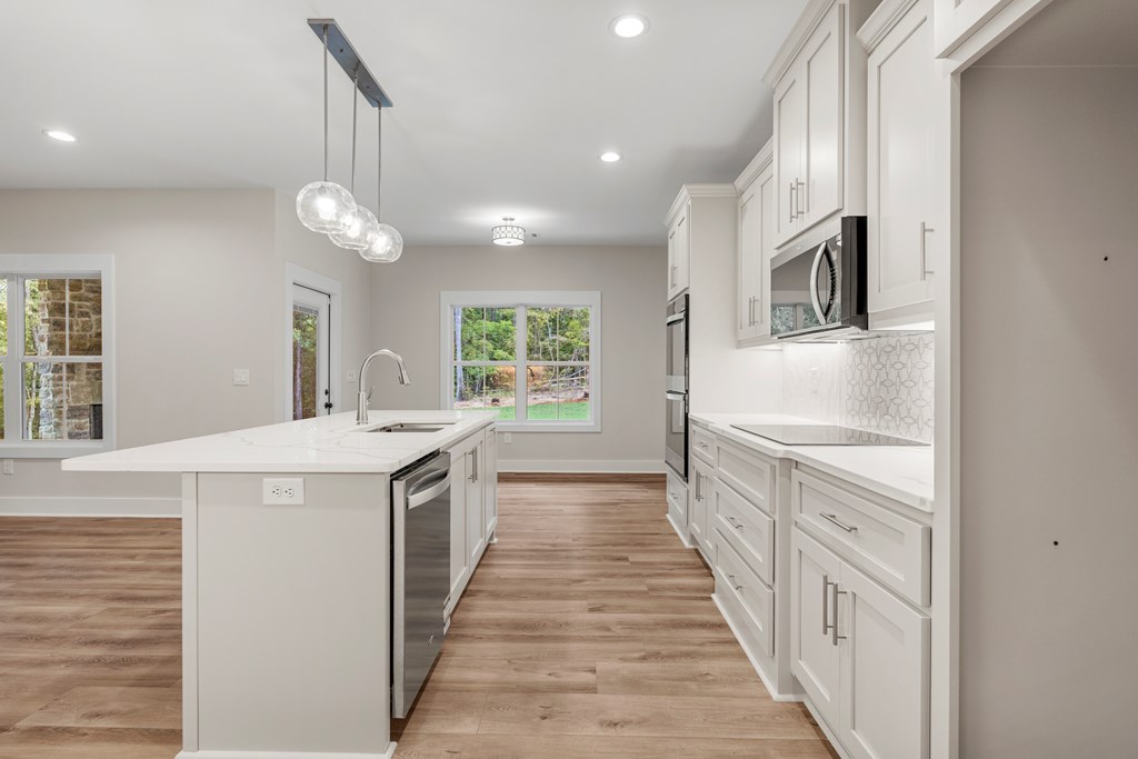 299 Ridgeway Drive Cataula, GA 31804 - Photo 17 of 52 a kitchen with granite countertop a sink and dishwasher a stove top oven with wooden floor