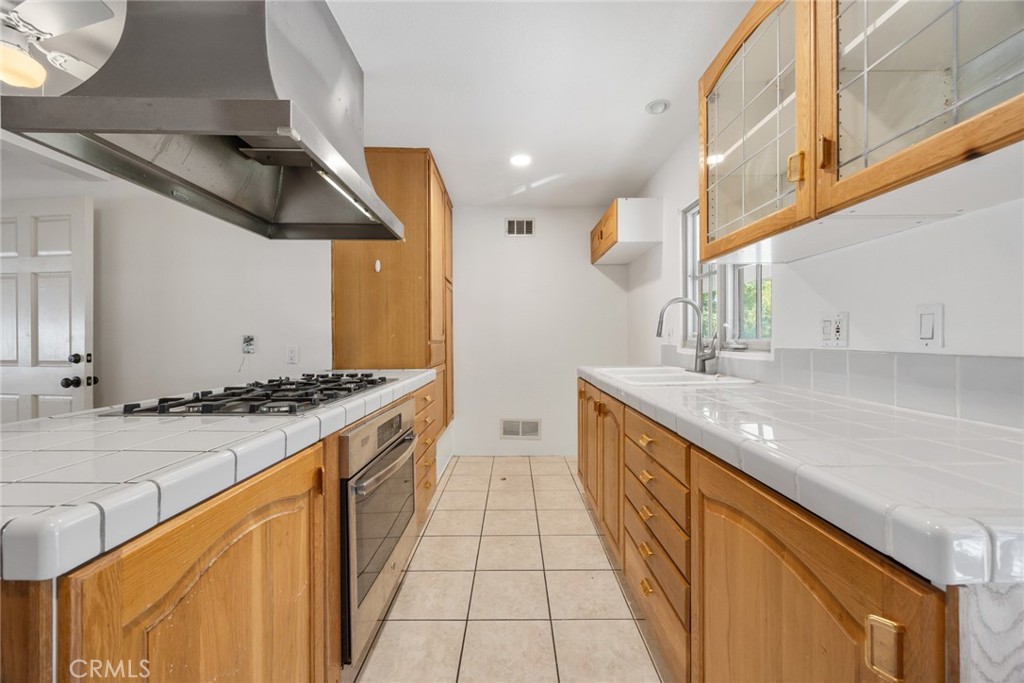101 Hampden Terrace Alhambra, CA 91801 - Photo 11 of 46 a kitchen with stainless steel appliances granite countertop a sink and a stove