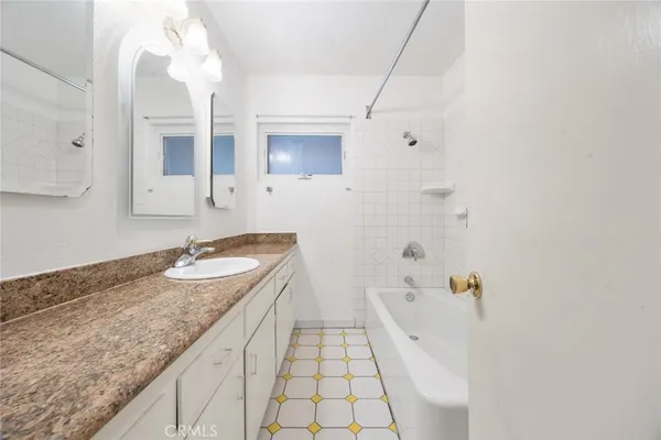 a spacious bathroom with a granite countertop sink and a mirror