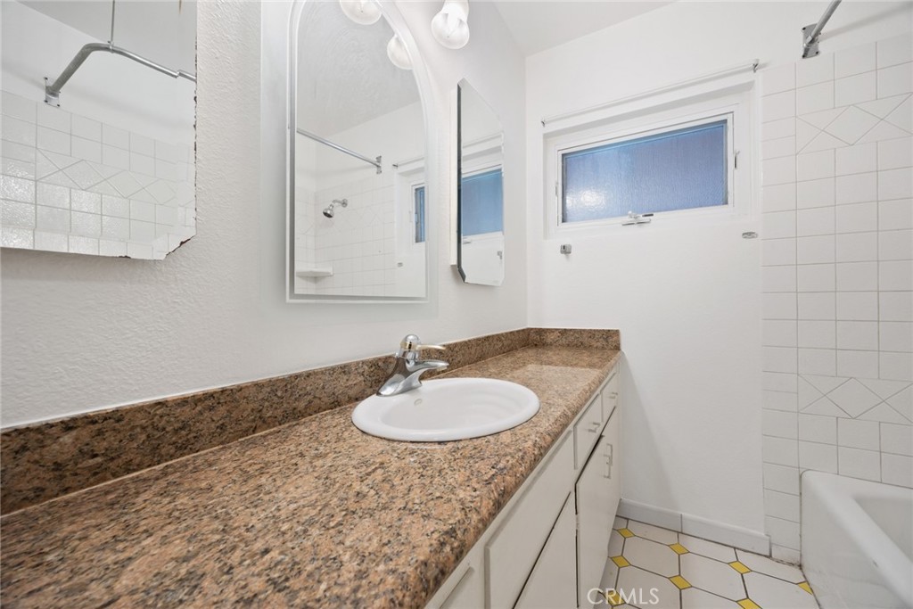 101 Hampden Terrace Alhambra, CA 91801 - Photo 21 of 46 a bathroom with a granite countertop sink a mirror and vanity