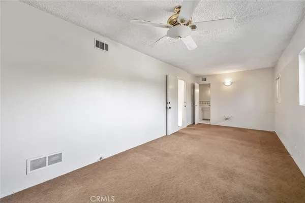 an empty room with windows and fan