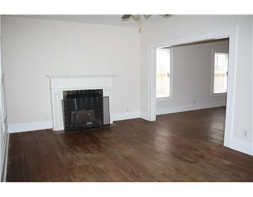 a view of empty room with wooden floor and fireplace