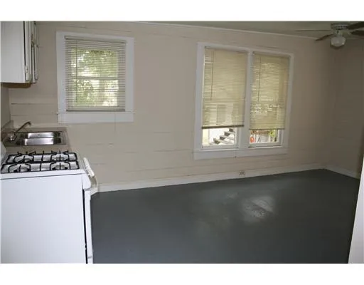 a kitchen with a stove a refrigerator and a window