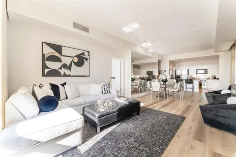 a living room with furniture and view of kitchen