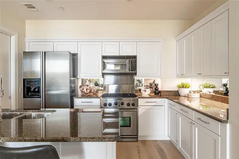 a kitchen with stainless steel appliances granite countertop a stove a sink and a refrigerator